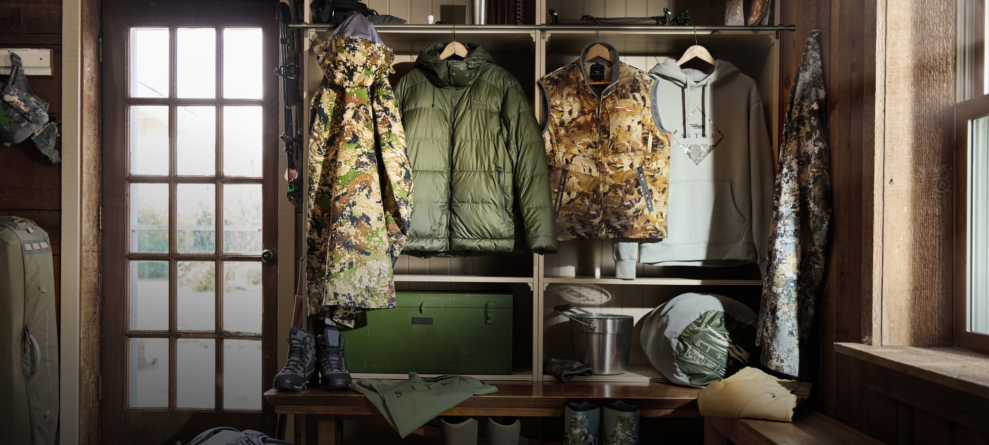 Jackets, vests and gear hung in a mud room | SITKA Holiday Gift Guide