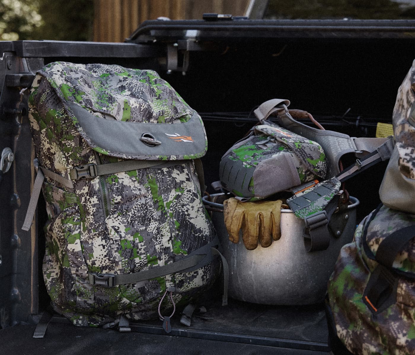 Assortment of Stocking Stuffers containing SITKA Tees, Hats, and Product Care in the Drifter Duffle 50L in Optifade Elevated | SITKA Gear Holiday Gift Guide