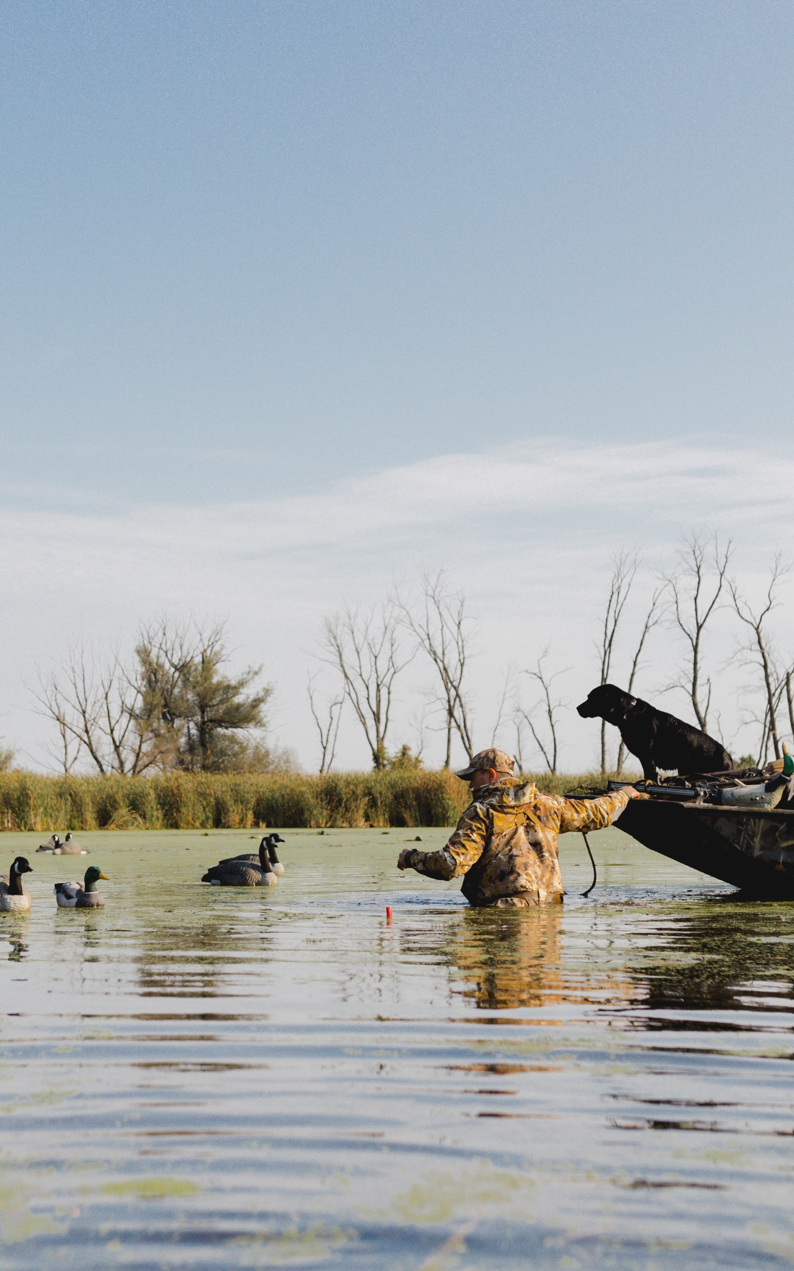 Man tugging his boat whilst collecting his decoy spread | SITKA Gear