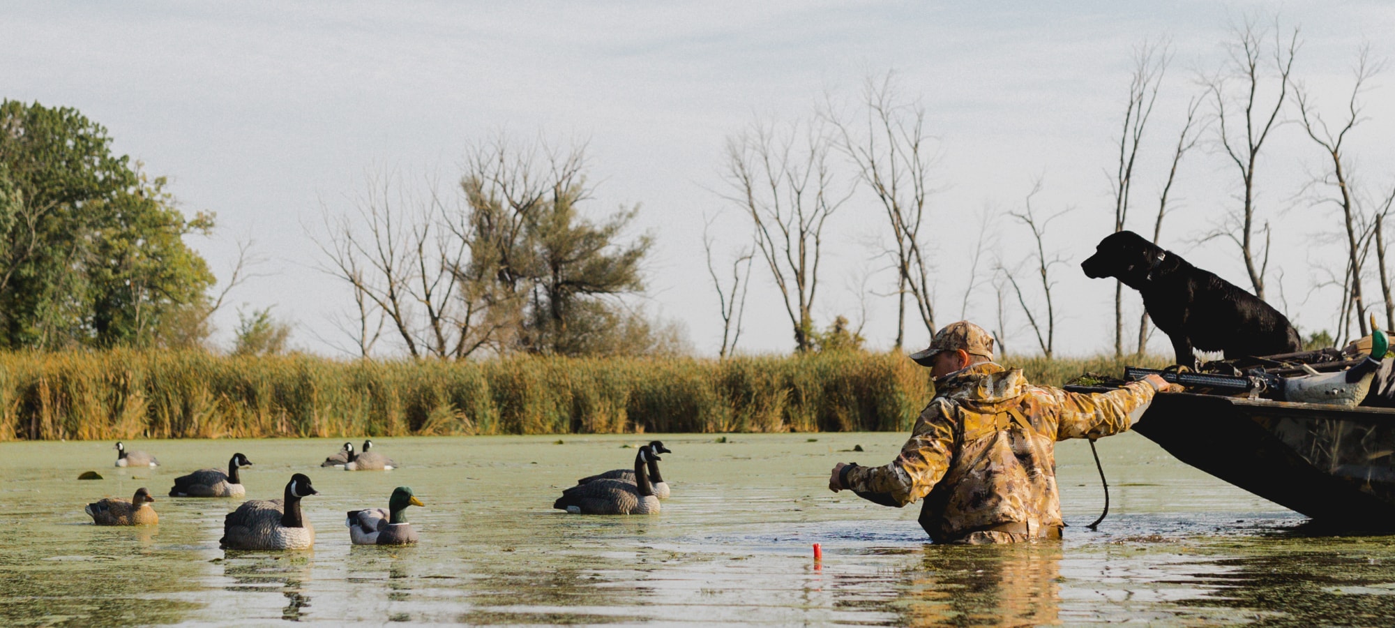 Man tugging his boat whilst collecting his decoy spread | SITKA Gear