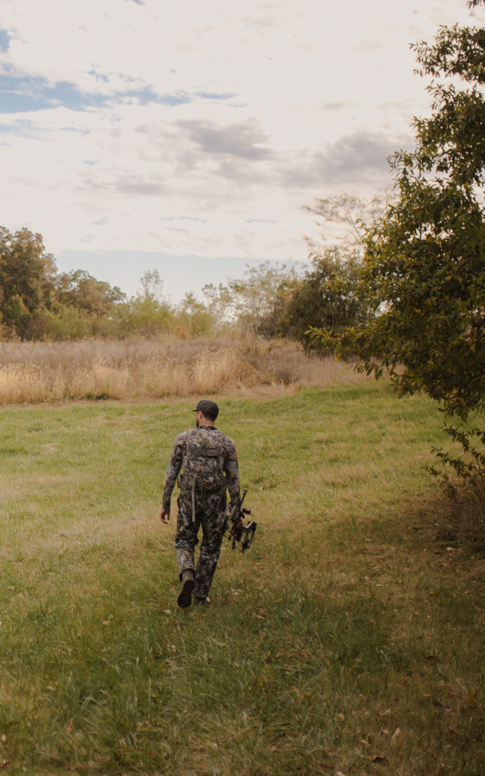 Man walking to his treestand on a field edge | SITKA Gear