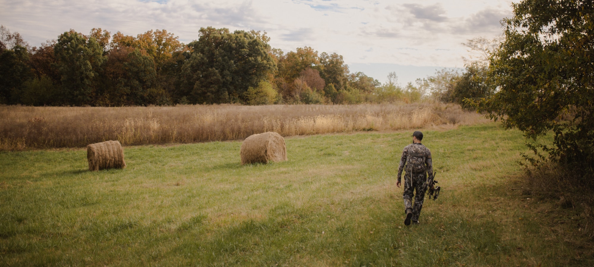 Man walking to his treestand on a field edge | SITKA Gear